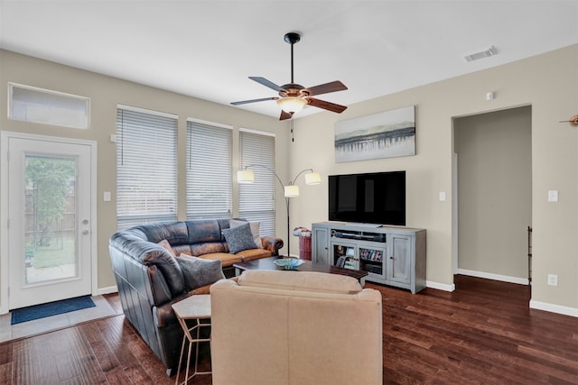 living room featuring dark wood-type flooring and ceiling fan