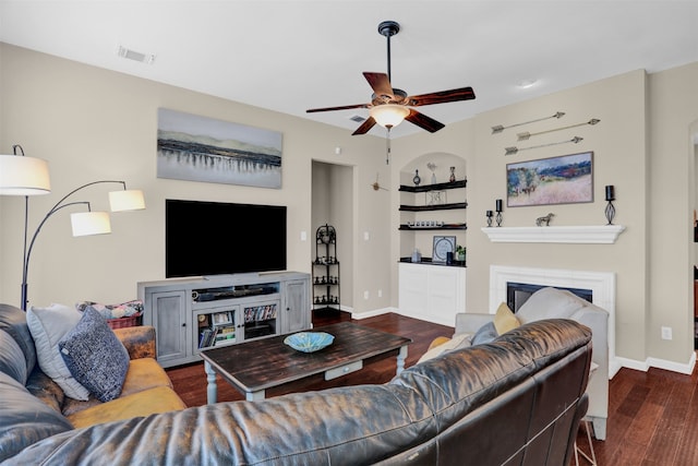 living room with dark wood-type flooring and ceiling fan