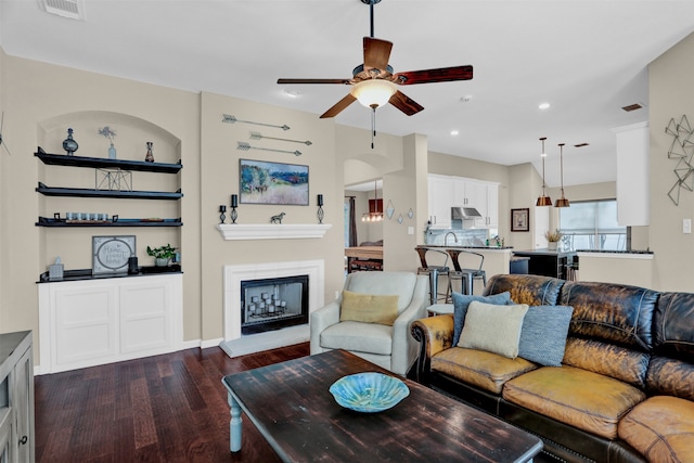 living room with ceiling fan, sink, and dark hardwood / wood-style floors