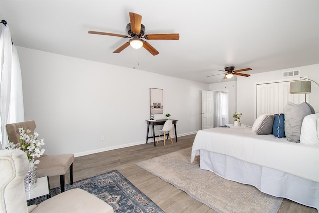 bedroom featuring hardwood / wood-style flooring, ceiling fan, and a closet