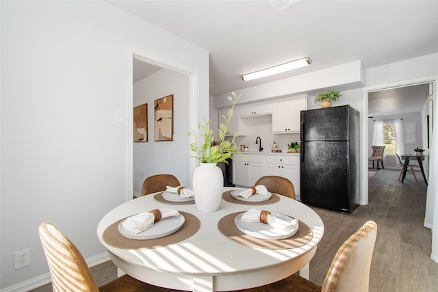 dining space with dark hardwood / wood-style flooring and sink