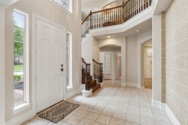 tiled entrance foyer featuring plenty of natural light and a high ceiling