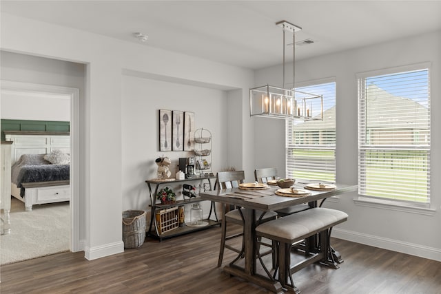 dining area featuring a notable chandelier and dark wood-type flooring