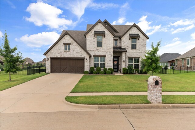 french country style house featuring a front yard and a garage