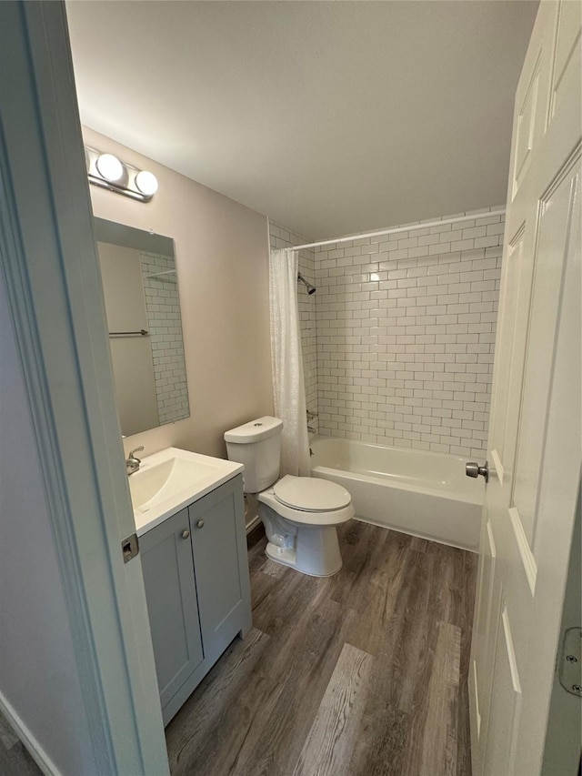 full bathroom with vanity, hardwood / wood-style flooring, shower / bath combination with curtain, and toilet