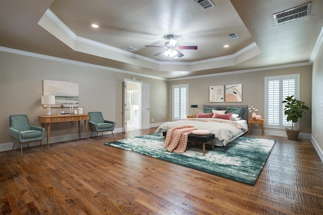 bedroom with ceiling fan, a tray ceiling, hardwood / wood-style flooring, and ornamental molding