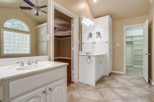 bathroom with vaulted ceiling, tile patterned flooring, ceiling fan, ornamental molding, and double sink vanity