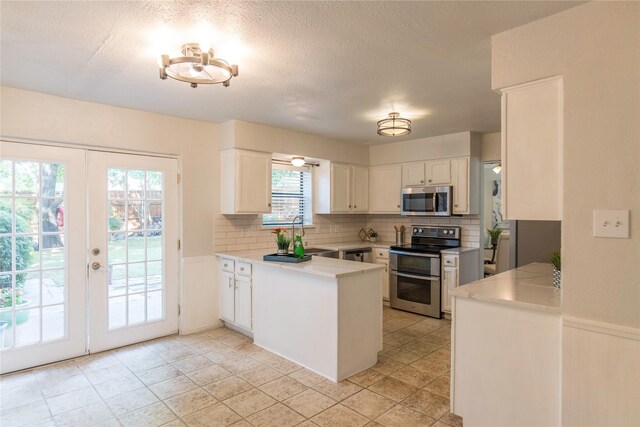 kitchen featuring french doors, sink, decorative backsplash, white cabinets, and appliances with stainless steel finishes