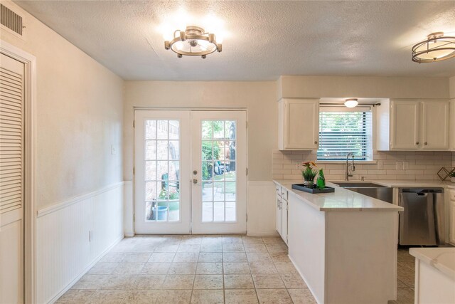 kitchen featuring dishwasher, french doors, plenty of natural light, decorative backsplash, and white cabinets