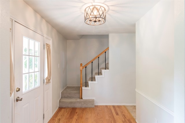 entryway with an inviting chandelier and light hardwood / wood-style flooring