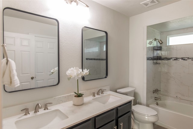 full bathroom featuring tiled shower / bath combo, toilet, and vanity