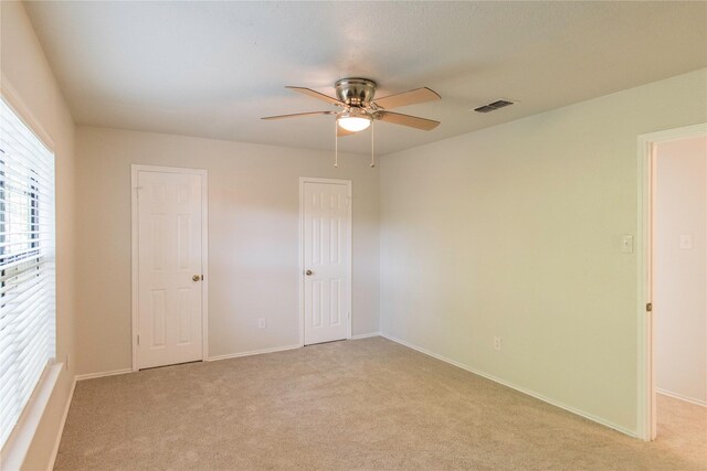 spare room featuring light carpet and ceiling fan