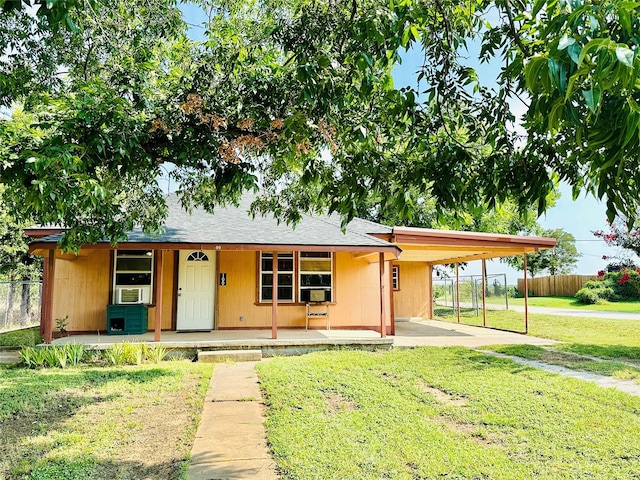 single story home featuring a front yard, a porch, and a carport