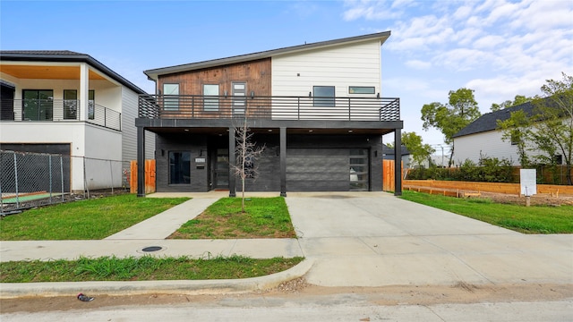 contemporary home featuring a garage, a balcony, and a front lawn