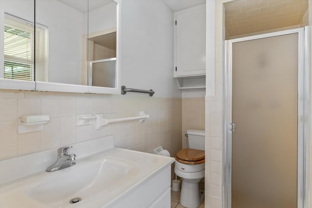 bathroom with toilet, tile patterned flooring, and tile walls