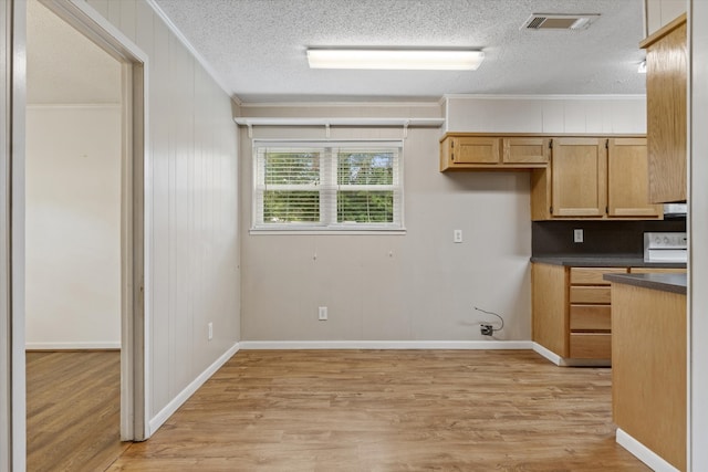 kitchen with range, light wood-type flooring, ornamental molding, and a textured ceiling