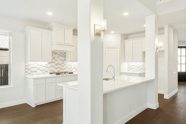 kitchen featuring stainless steel gas stovetop, sink, dark wood-type flooring, and white cabinets