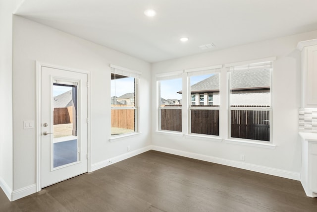 interior space featuring dark wood-type flooring and a healthy amount of sunlight