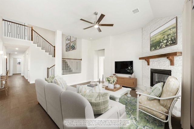 living room featuring ceiling fan, a fireplace, and dark hardwood / wood-style floors