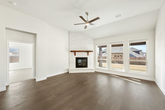 unfurnished living room featuring ceiling fan, dark hardwood / wood-style flooring, vaulted ceiling, and a fireplace