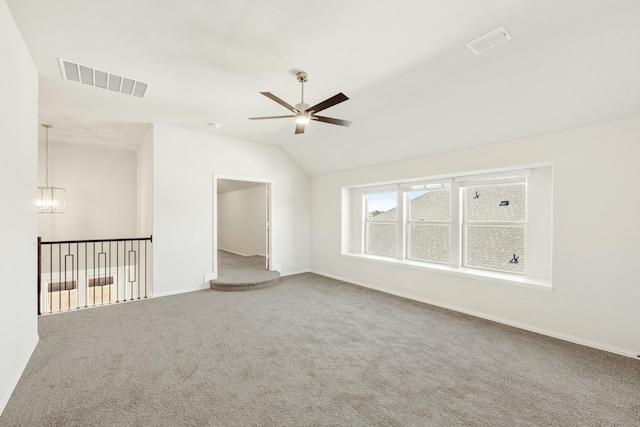 carpeted spare room with lofted ceiling and ceiling fan with notable chandelier