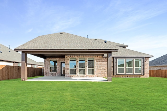 rear view of property featuring a lawn and a patio area