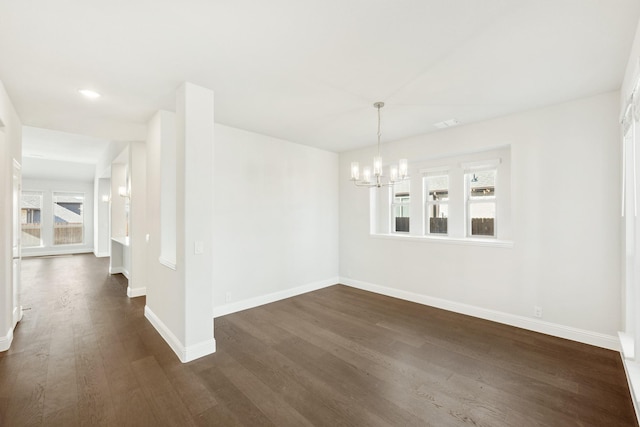 unfurnished dining area with dark hardwood / wood-style floors and a chandelier