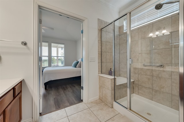 bathroom featuring tile patterned flooring, crown molding, a shower with shower door, vanity, and ceiling fan