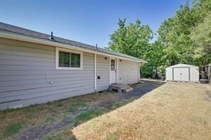 rear view of house featuring an outdoor structure and a storage shed