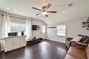 living area featuring visible vents, lofted ceiling, a wealth of natural light, and a ceiling fan