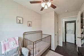 bedroom featuring ceiling fan, a crib, and hardwood / wood-style floors