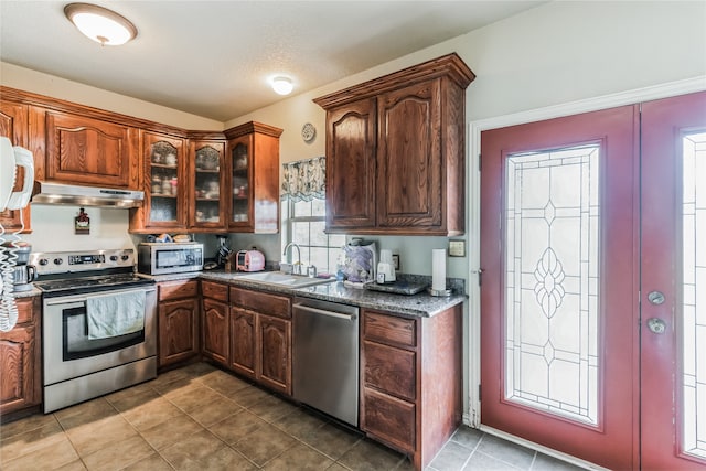 kitchen with a textured ceiling, stainless steel appliances, sink, and tile patterned floors