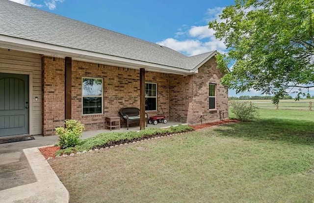 rear view of property featuring a patio and a yard