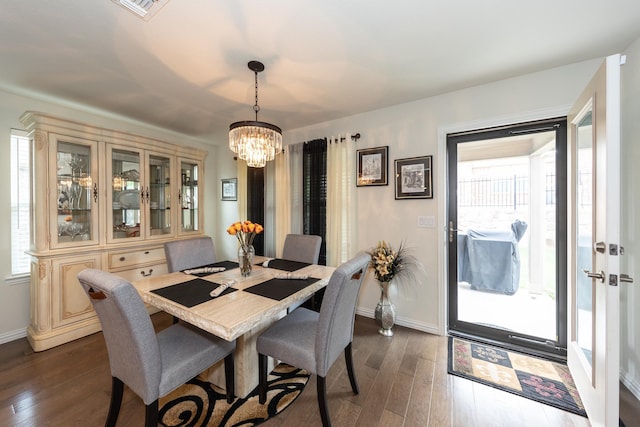 dining area with a notable chandelier and dark hardwood / wood-style floors