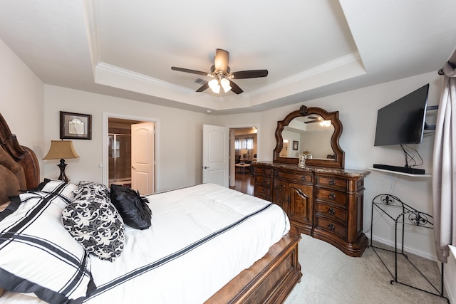 carpeted bedroom featuring connected bathroom, ornamental molding, a raised ceiling, and ceiling fan