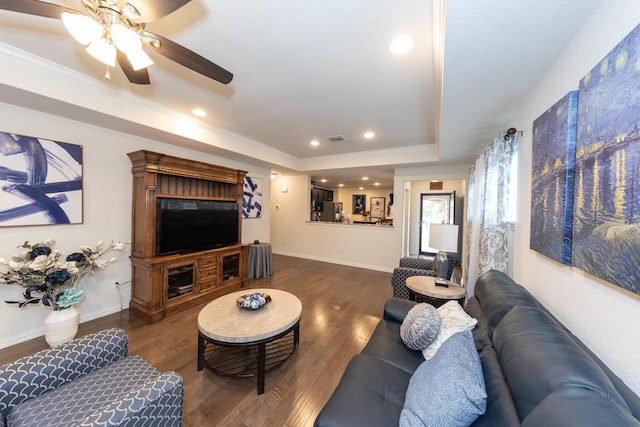 living room featuring crown molding, dark hardwood / wood-style floors, ceiling fan, and a tray ceiling