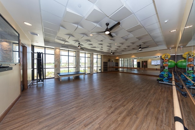 interior space with dark wood-type flooring, ceiling fan, and a wall of windows