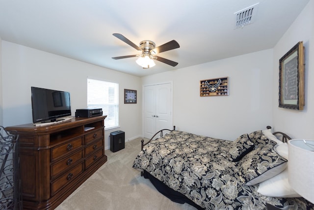 carpeted bedroom with ceiling fan and a closet