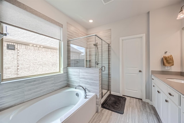 bathroom with vanity and independent shower and bath