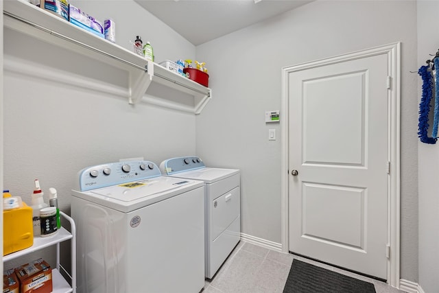 laundry area with washer and dryer and light tile patterned floors