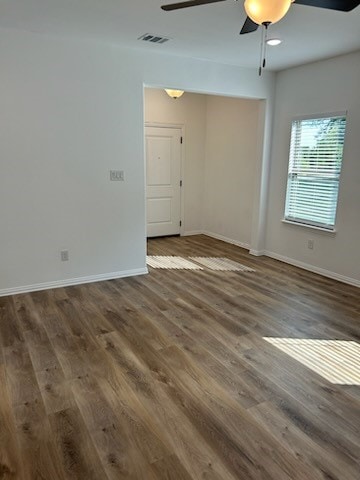 unfurnished room featuring ceiling fan and dark wood-type flooring