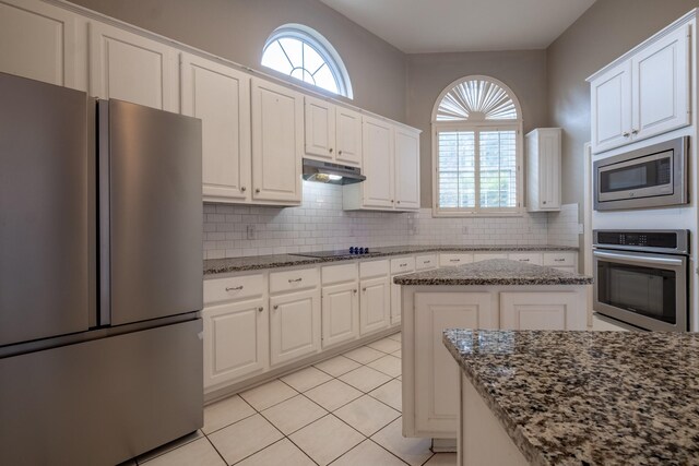 kitchen featuring a center island, a healthy amount of sunlight, backsplash, and appliances with stainless steel finishes