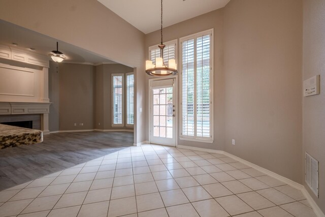 unfurnished living room with light hardwood / wood-style flooring and a chandelier