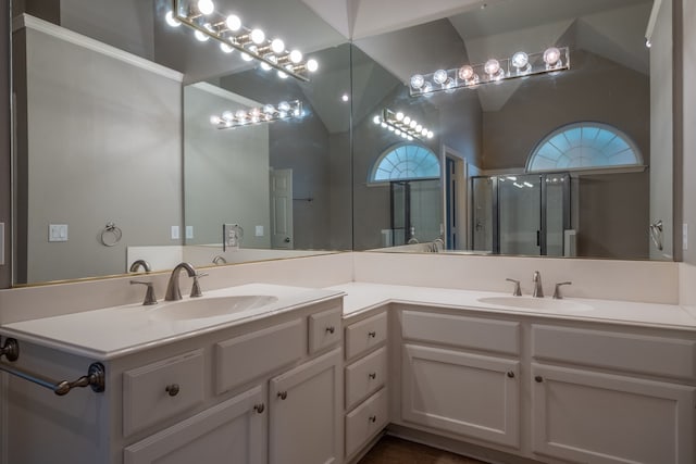 bathroom with dual vanity and vaulted ceiling