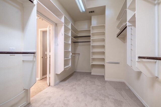 spacious closet featuring light carpet