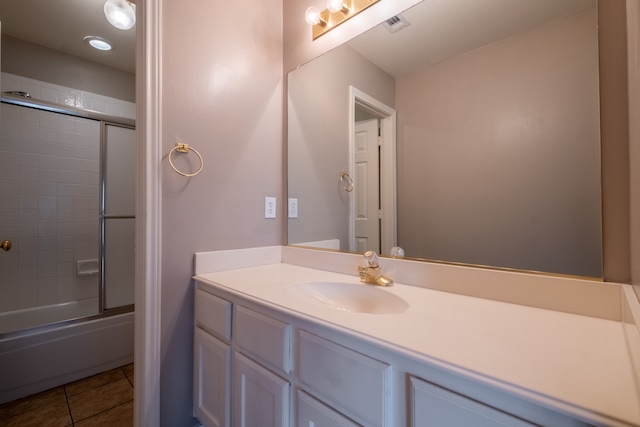 bathroom featuring tile patterned flooring, shower / bath combination with glass door, and vanity