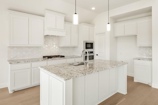 kitchen featuring white cabinetry, sink, decorative light fixtures, and stainless steel appliances