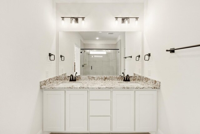 bathroom featuring vanity and a shower with door