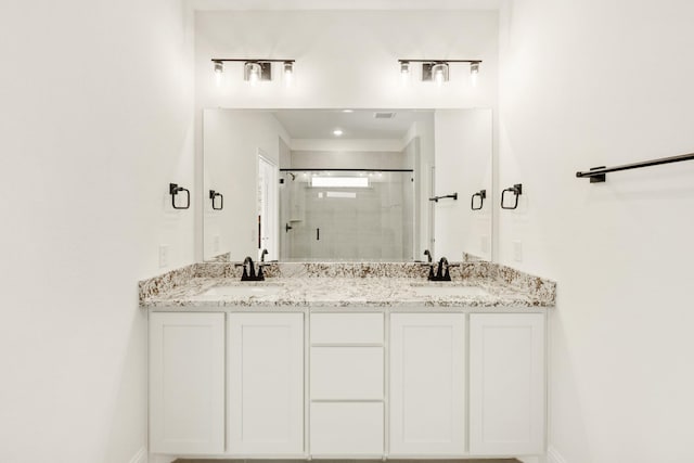 bathroom with a shower with door and vanity