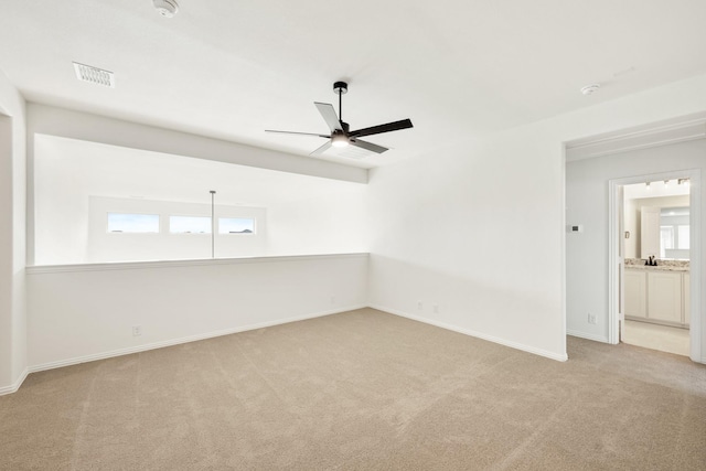 carpeted spare room with ceiling fan